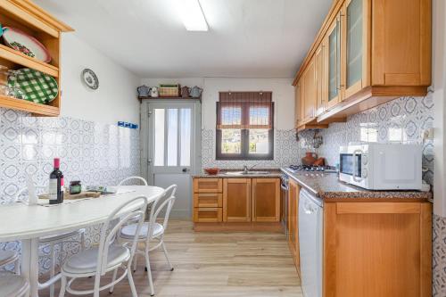 a kitchen with wooden cabinets and a table with a microwave at Casa da Varzinha in A dos Cunhados