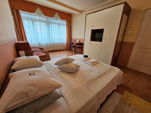 a hotel room with two beds and a television at Abigél 2 Vendégház in Miskolctapolca