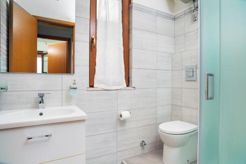 a bathroom with a toilet and a sink and a mirror at Casa Vacanza Vista Mare in SantʼAlessio Siculo