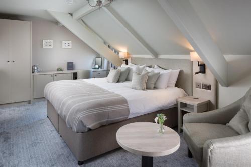 a bedroom with a large white bed and a couch at Aysgarth Falls Hotel & Restaurant in Aysgarth
