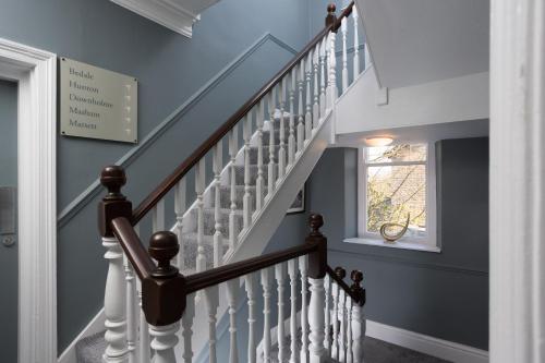a staircase with white railings and a window at Aysgarth Falls Hotel & Restaurant in Aysgarth