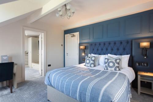 ein blaues Schlafzimmer mit einem Bett und einer blauen Wand in der Unterkunft Aysgarth Falls Hotel & Restaurant in Aysgarth