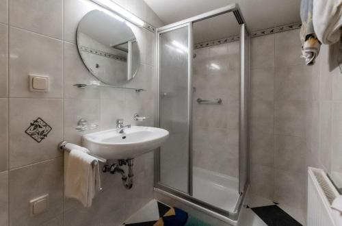 La salle de bains est pourvue d'une douche et d'un lavabo. dans l'établissement Ferienwohnung Hartlgut, à Bad Hofgastein
