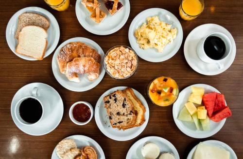 een tafel met daarop borden met verschillende soorten ontbijtproducten bij Melincue Casino & Resort in Melincué