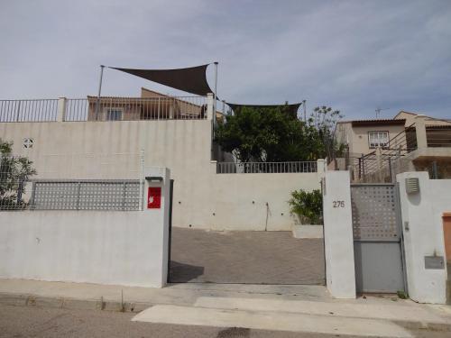 ein weißes Gebäude mit einem Tor und einem Zaun in der Unterkunft LAS PALOMAS, appartement 3 chambres avec piscine in Turís
