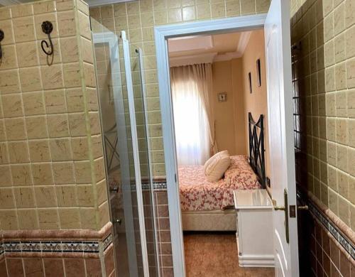Dormitorio pequeño con cama y ducha en Excelente piso en San Fernando, en San Fernando