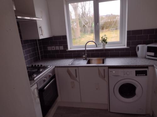 a kitchen with a sink and a washing machine at 3/4 bedroom detached, Mauricewood Park EH26 in Penicuik