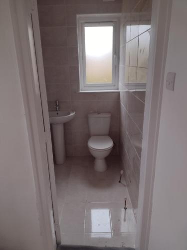 a small bathroom with a toilet and a window at 3/4 bedroom detached, Mauricewood Park EH26 in Penicuik