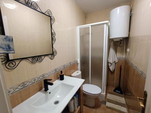 y baño con lavabo, aseo y espejo. en apartamento en el parque natural del cabo de gata en Almería