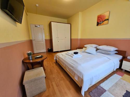 a bedroom with a bed and a table and a television at Abigél 2 Vendégház in Miskolctapolca