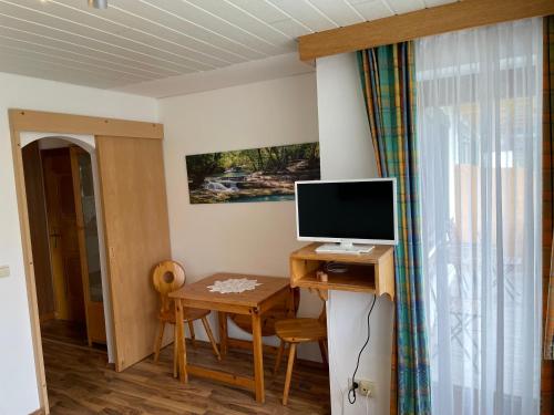 a room with a desk with a computer monitor on it at Landhaus Sonne in Maishofen