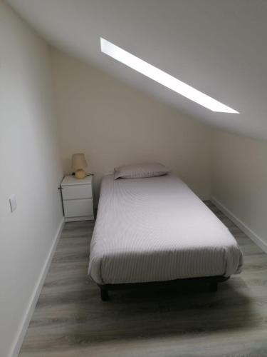 1 dormitorio con 1 cama en una habitación blanca en Casa da Marina II, en Esposende