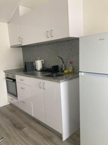 eine Küche mit weißen Schränken und einem weißen Kühlschrank in der Unterkunft Casa da Marina II in Esposende