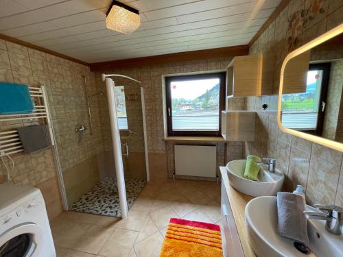 y baño con lavabo y lavadora. en Landhaus Sonne, en Maishofen