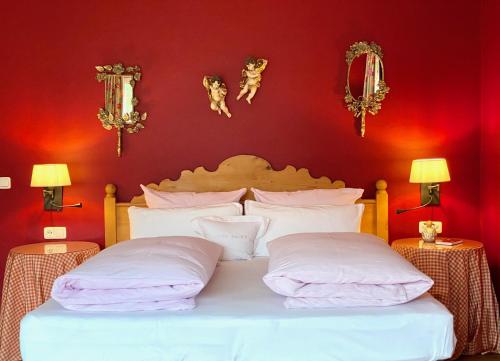 a bedroom with a white bed with red walls at Landhaus am Stein in Bad Wiessee