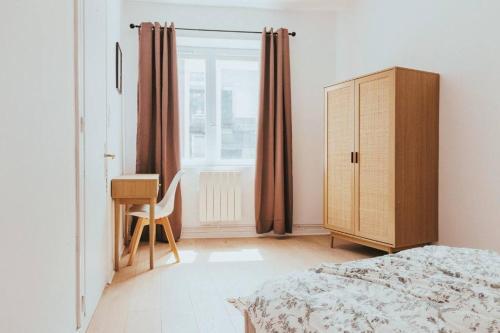 a bedroom with a bed and a dresser and a window at CAP VERT - Appartement Cocooning Chic in Saint-Étienne