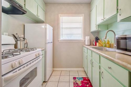 a kitchen with green cabinets and a white refrigerator at Cozy & Comfy - Few blocks away from Plaza District in Oklahoma City
