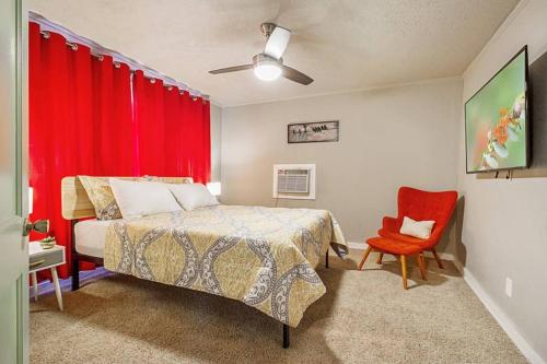 een slaapkamer met een bed en een rood gordijn bij Cozy & Comfy - Few blocks away from Plaza District in Oklahoma City