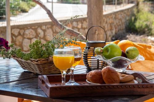 a table with a basket of fruit and a glass of orange juice at Maria Nik Psaras House in Kalymnos