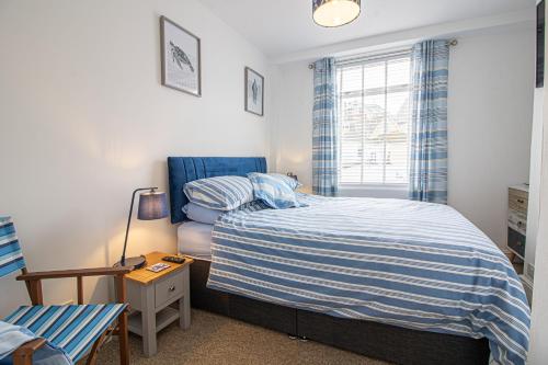 a small bedroom with a bed and a window at Saltwhistle Beach- Couples Retreat in Teignmouth