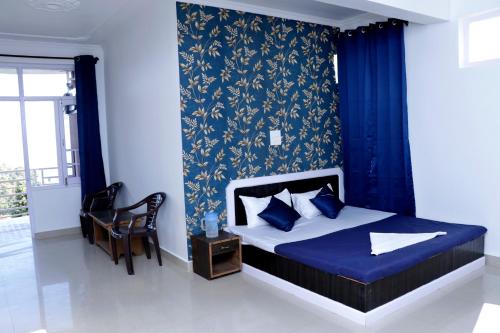 Schlafzimmer mit einem Bett mit blauer Bettwäsche und blauen Vorhängen in der Unterkunft Himalayan Homestay in Dharamshala