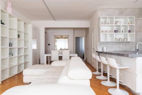 uma sala de estar com cadeiras brancas e um balcão em Bilocale vista sul Duomo di Milano em Milão