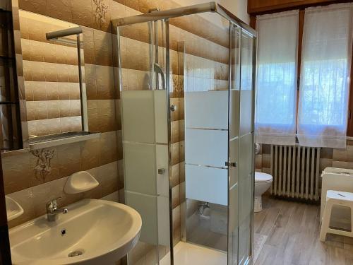 ein Bad mit einem Waschbecken und einer Glasdusche in der Unterkunft Sole in Rimini
