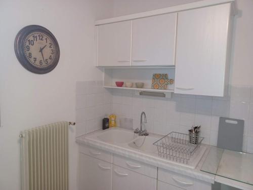 a kitchen with a sink and a clock on the wall at Le Panoramique in Bourges