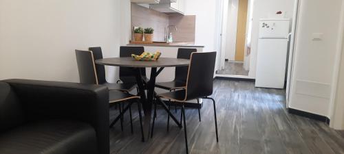 uma cozinha com uma mesa com cadeiras e um frigorífico em Appartamento Ambrosia em Manarola