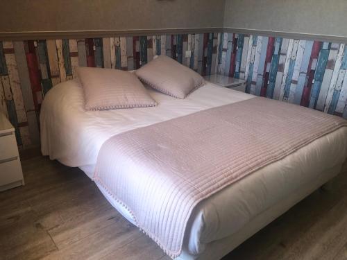 a bed with white sheets and pillows in a room at Les Belles Terrasses in Tourrettes-sur-Loup