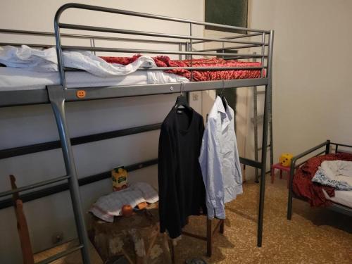 ein Schlafzimmer mit einem Etagenbett mit Kleidung in der Unterkunft Casa dei GATTI in Turin