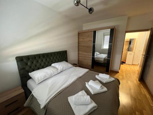 a bedroom with a large bed with two towels on it at Apartman Didi-free parking in Novi Sad