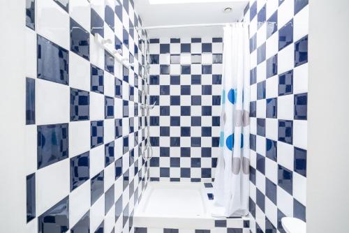 een badkamer met zwart-wit geruite tegels bij Vacances en duo au Guilvinec ! in Le Guilvinec