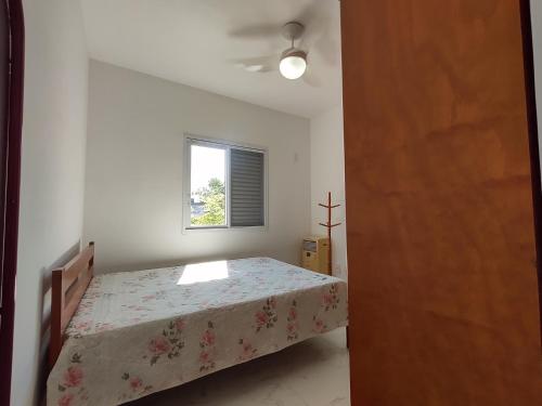 Apartamento a 100 metros da Praia في بيرتيوغا: غرفة نوم بسرير ونافذة