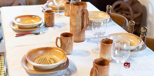 a table with plates and wine glasses on it at Chalet il Palmento del Vulcano in Bronte