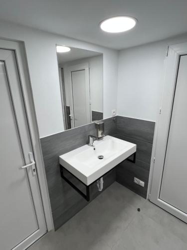 La salle de bains est pourvue d'un lavabo blanc et d'un miroir. dans l'établissement Yellow Hostel 24h - śniadanie i obiad gratis - Free Parking, à Katowice