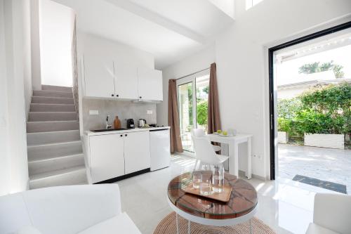 uma sala de estar com uma mesa e uma cozinha em Alekos Luxury Suites Free 24h Transportation From - To Airport em Artemida