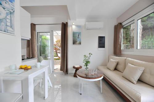 a white living room with a couch and a table at Alekos Luxury Suites Free 24h Transportation From - To Airport in Artemida