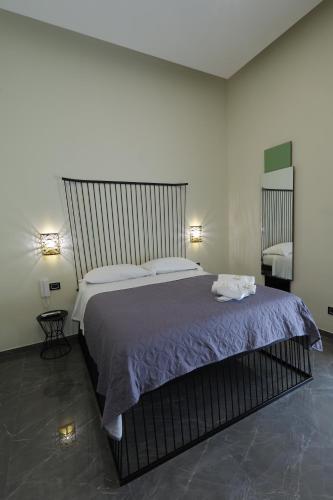 a bedroom with a large bed with purple sheets at Il Salotto della Regina in Naples