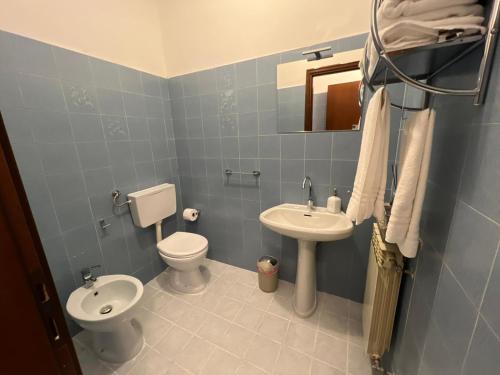 Baño azul con aseo y lavamanos en YOUR HOME OUTLET 6, en Serravalle Scrivia