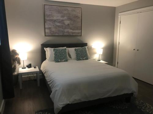 a bedroom with a large bed with two lamps at Hot Tub Hideaway in Shawnigan Lake