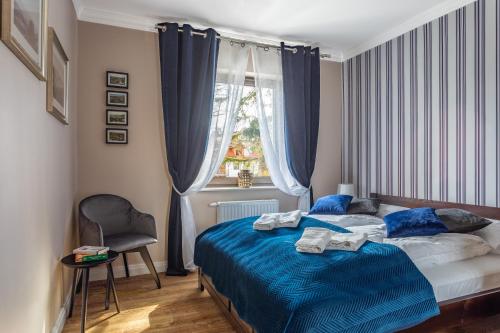 a bedroom with a bed with blue sheets and a window at Comfort Studio Stone Hill in Szklarska Poręba