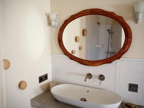 Un baño con un gran espejo y una bañera. en Casa Amandava, en Salobreña