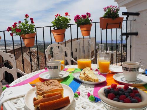 a table with plates of food and cups of orange juice at Casa Amandava in Salobreña
