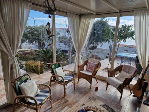a room with a porch with chairs and windows at B&B Cala Luna in Cala Gonone