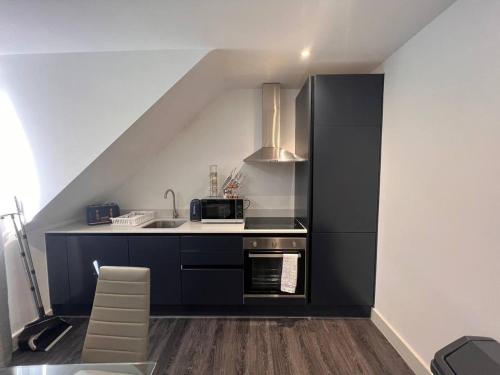 uma pequena cozinha com um lavatório e um fogão em Star London Finchley Road 3-Bed Haven em Londres