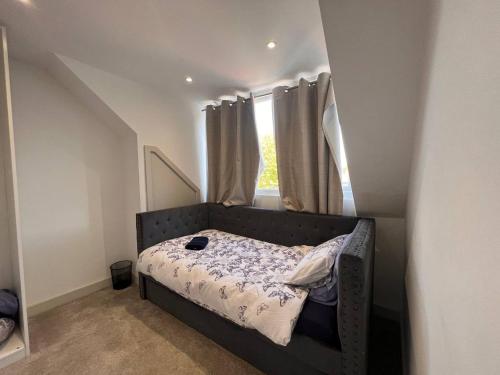 um pequeno quarto com uma cama e uma janela em Star London Finchley Road 3-Bed Haven em Londres