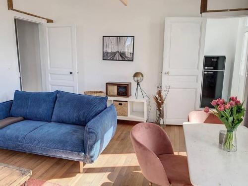 een woonkamer met een blauwe bank en een tafel bij Le Maurice 4 - Villa Maurice in Compiègne