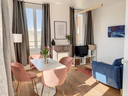 een woonkamer met een tafel en stoelen en een televisie bij Le Maurice 4 - Villa Maurice in Compiègne