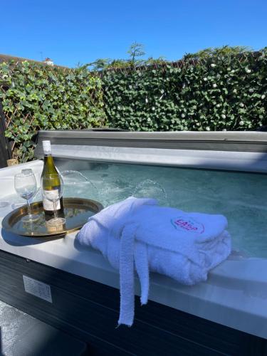 eine Badewanne mit einem Handtuch und einer Flasche Wein in der Unterkunft Casa North Coast in Portrush